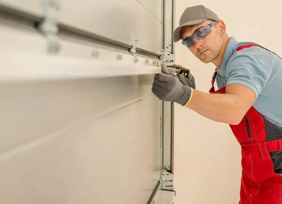 Technician adjusting a garage door track during maintenance